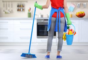 Rengöring koncept. Kvinna med golv mopp och hink med tvättvätskor, bakifrån